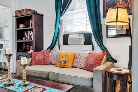 Comfy sofa piled w/ colorful pillows — made for relaxing evenings.
